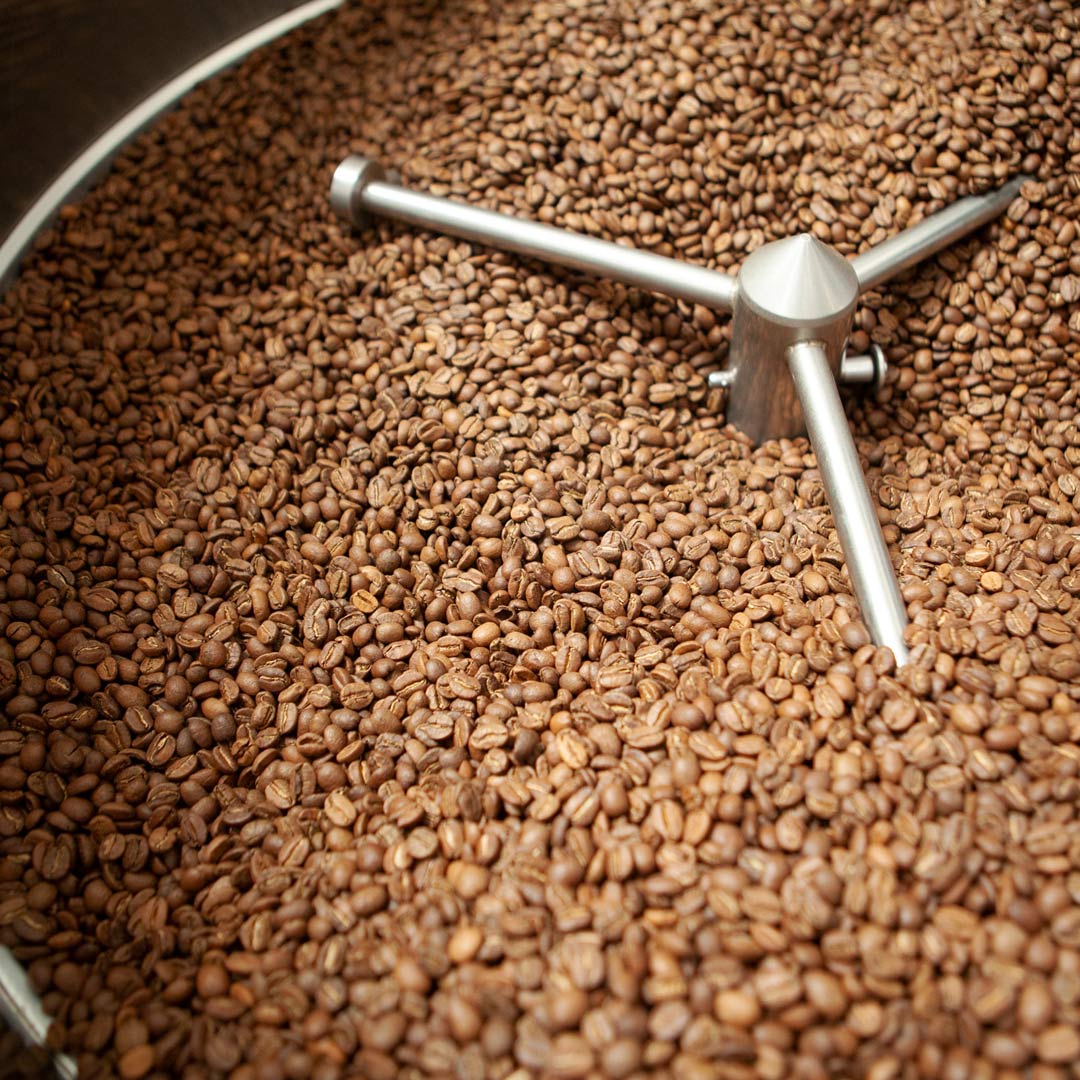 Light-roasted coffee cooling in a stainless steel roaster tray.